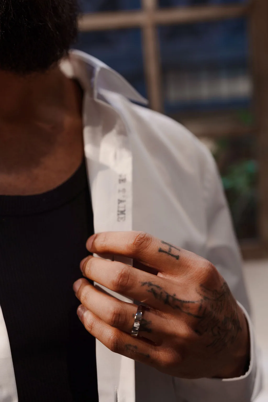 La main du marié sur sa chemise brodée « je t'aime »