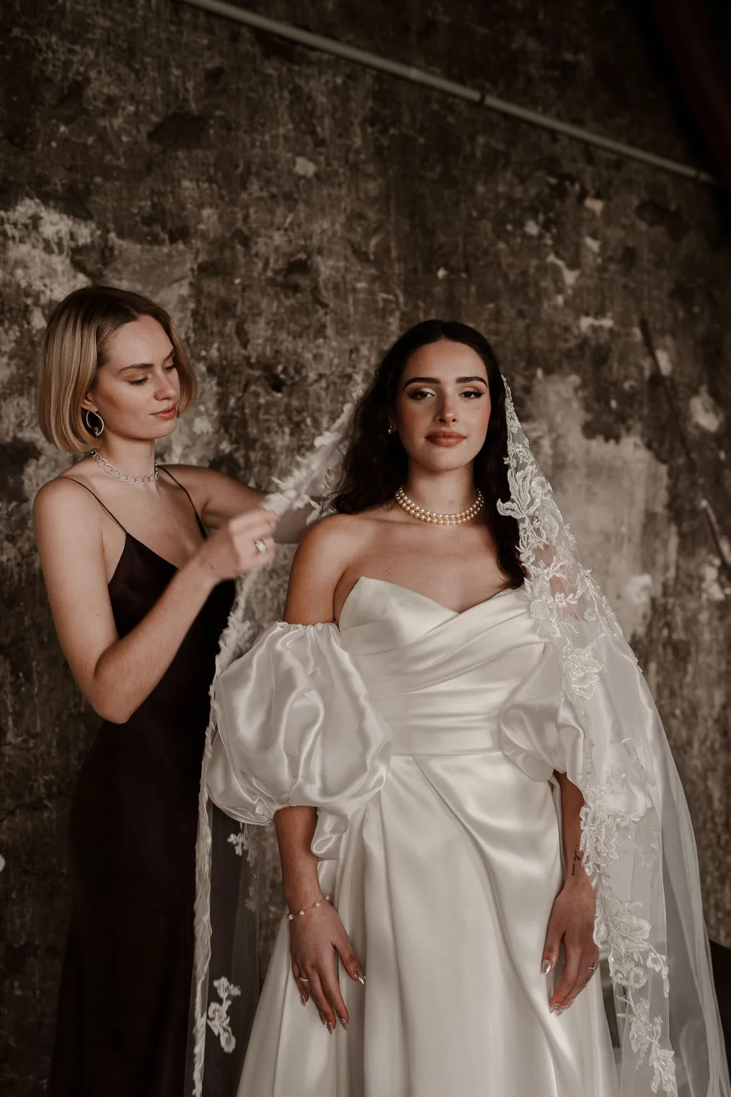 Deux amies ajustent la robe de la mariée