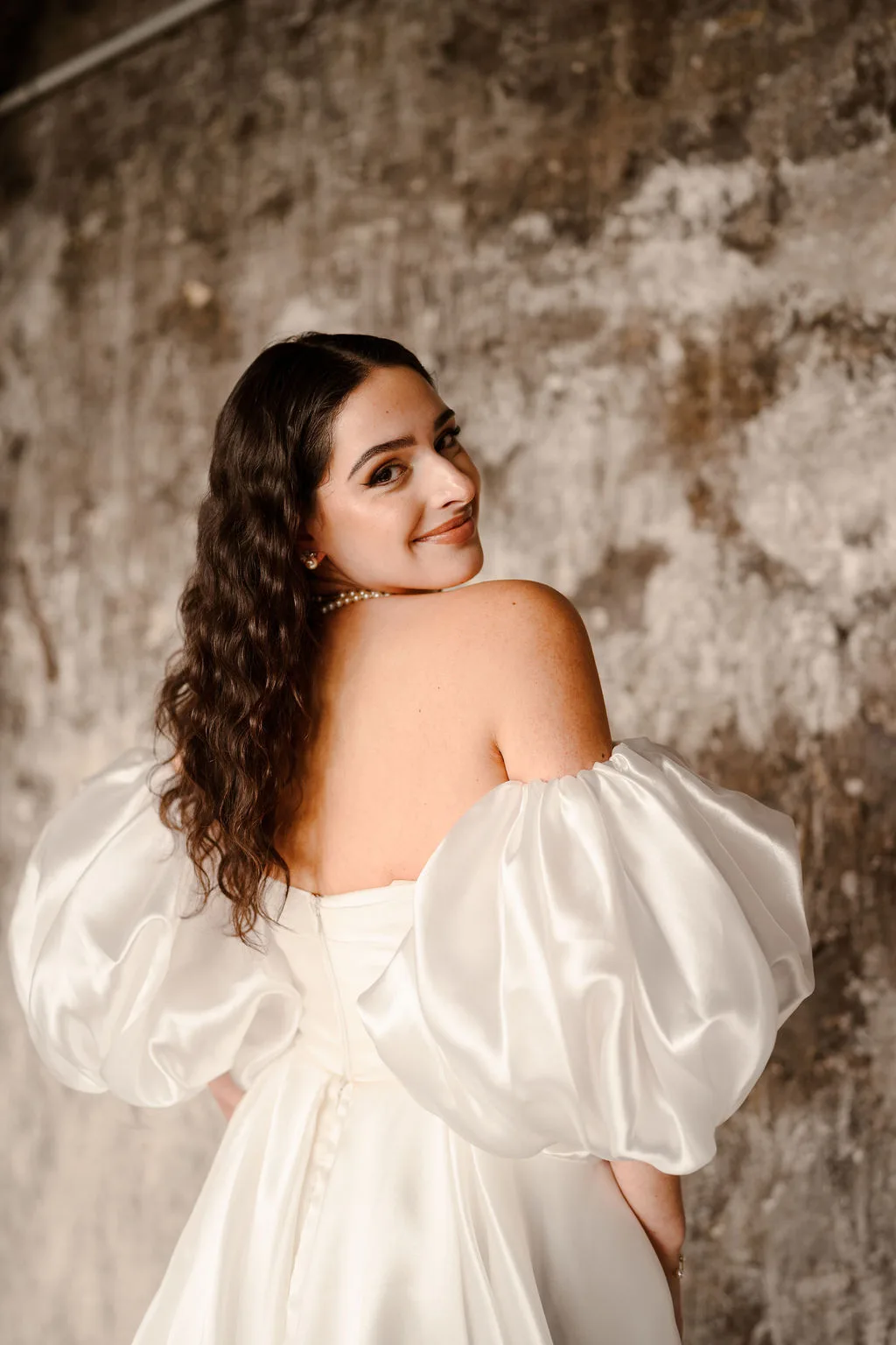 La mariée se retourne, sourire aux lèvres