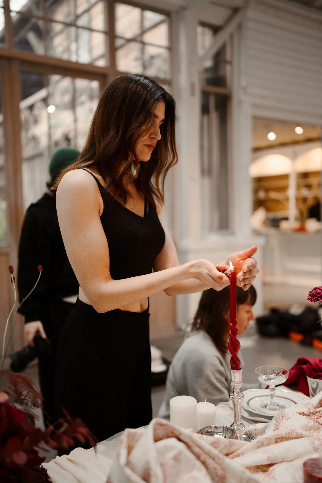 Sara, fondatrice de Minute Papillon, ajuste une bougie sur une table de mariage
